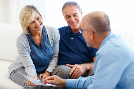 Aged care financial advice- photo of an older couple smiling speaking with a financial planner