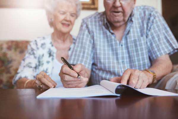 Compass image of two older people signing a will