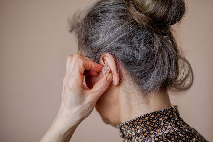 Woman putting hearing aid in