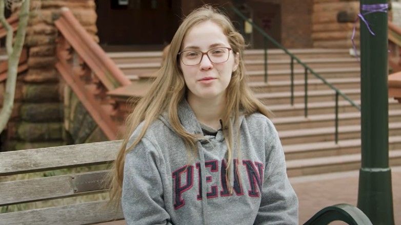 Talia in front of UPenn building with UPenn sweatshirt