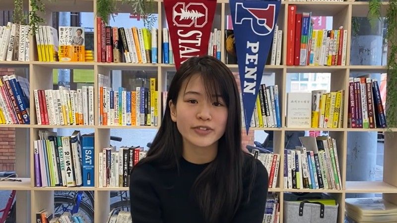 photo of Ayaka with books and college penants