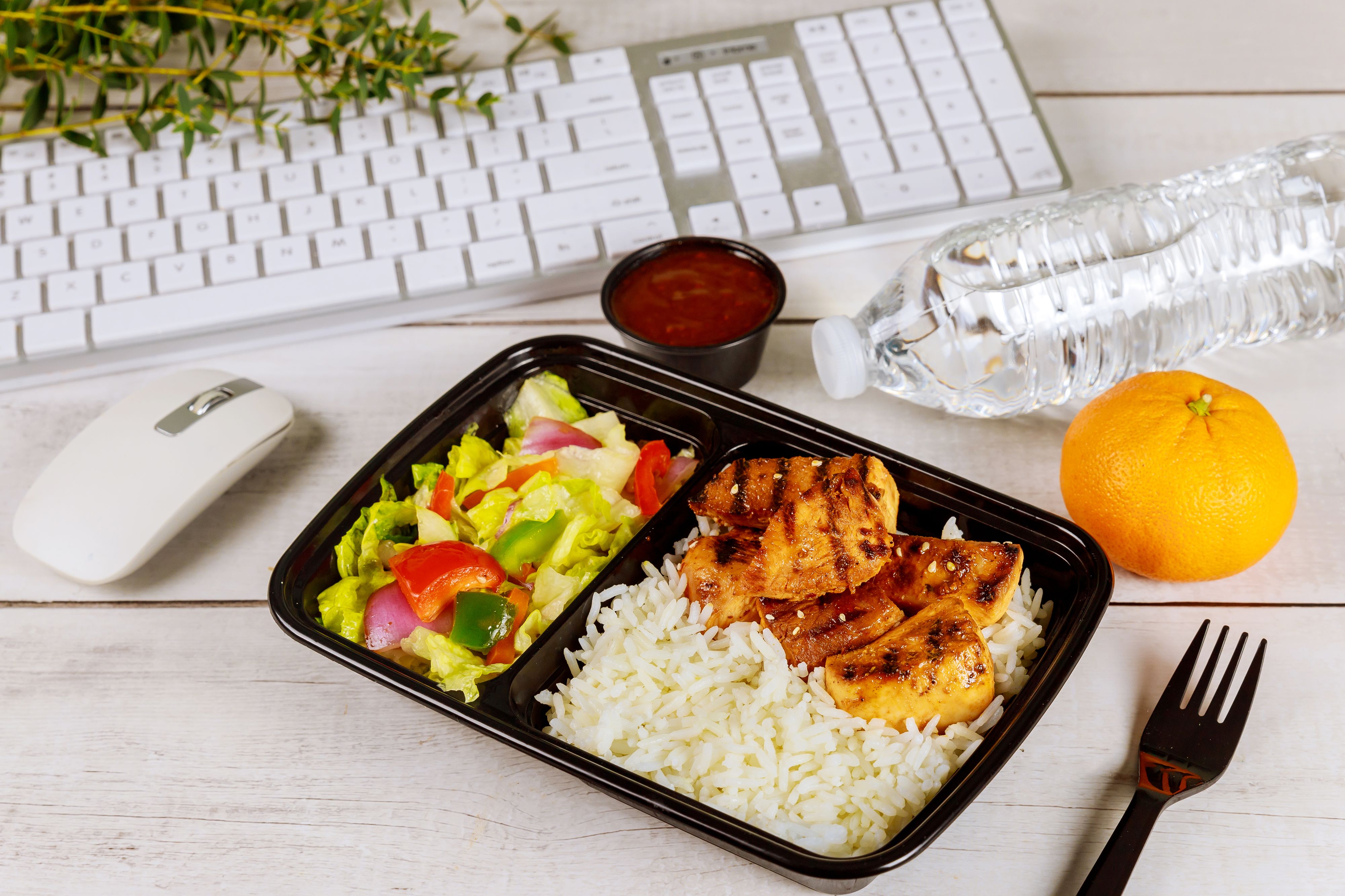 Boxed meal at desk in front of keyboard and mouse
