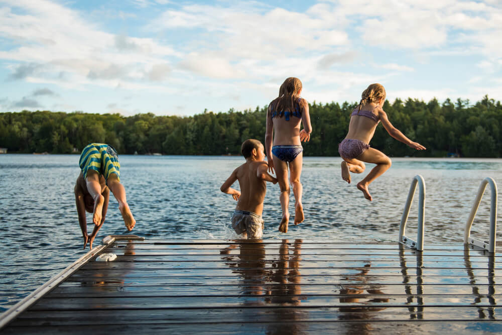 Děti skáčou do jezera