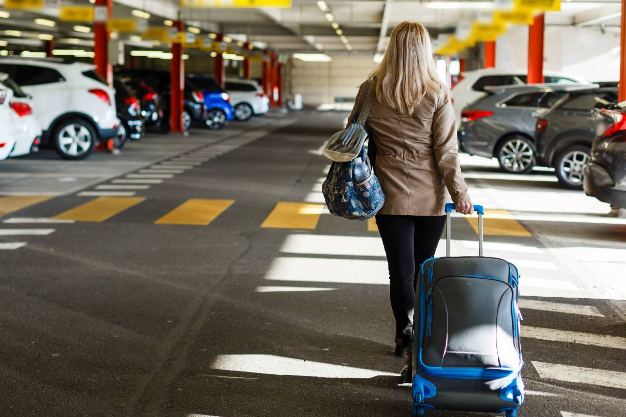 Jak nejlépe a nejlevněji zaparkovat při odletu na dovolenou - Žena na letištním parkovišti