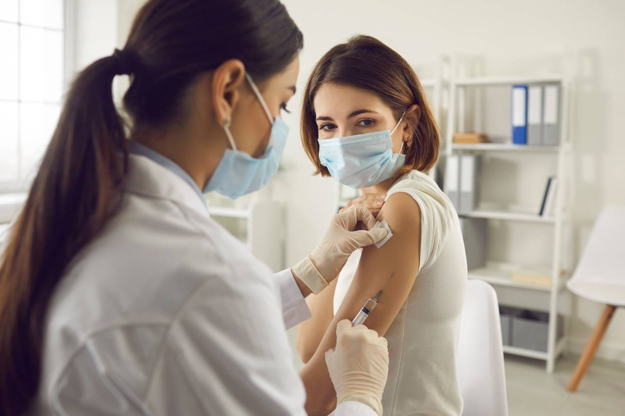 Očkování při cestě do zahraničí - Sestra očkuje pacientku do ramene