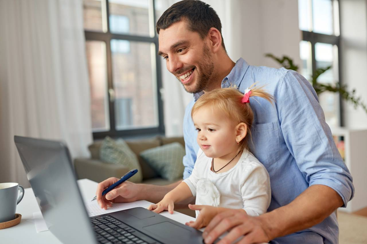 Rodič u laptopu s dítětem
