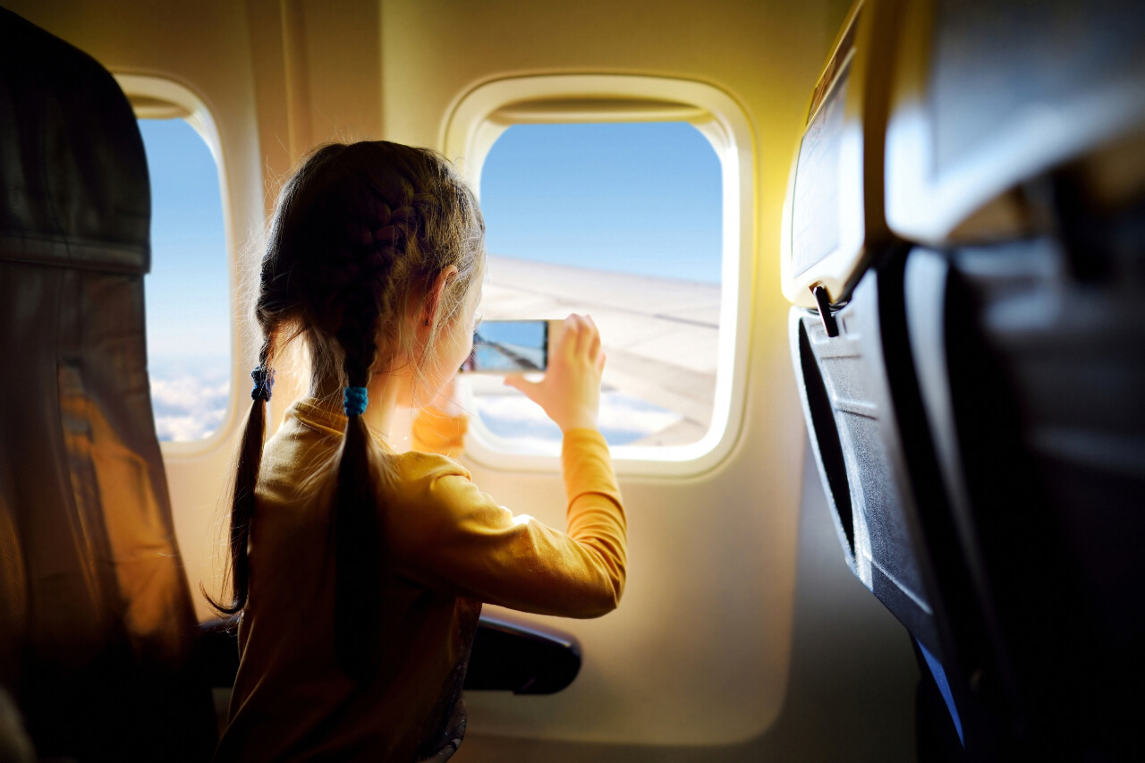 Malá holčička fotí výhled z letadla