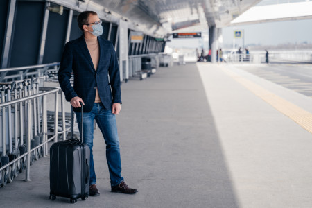 Muž s kufrom na letisku