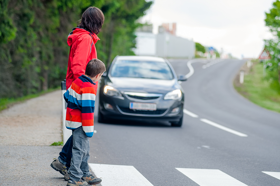žena s dieťaťom a prichádzajúce auto