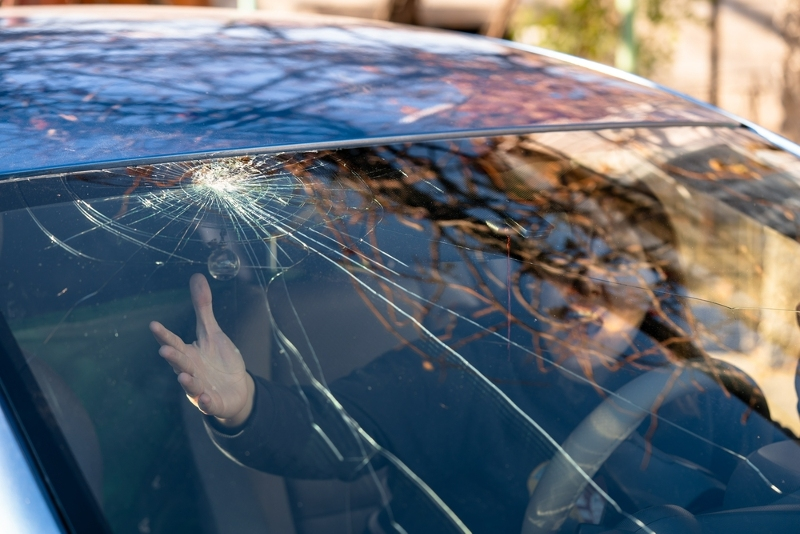 Rozbité čelní sklo - překvapený člověk uvnitř auta