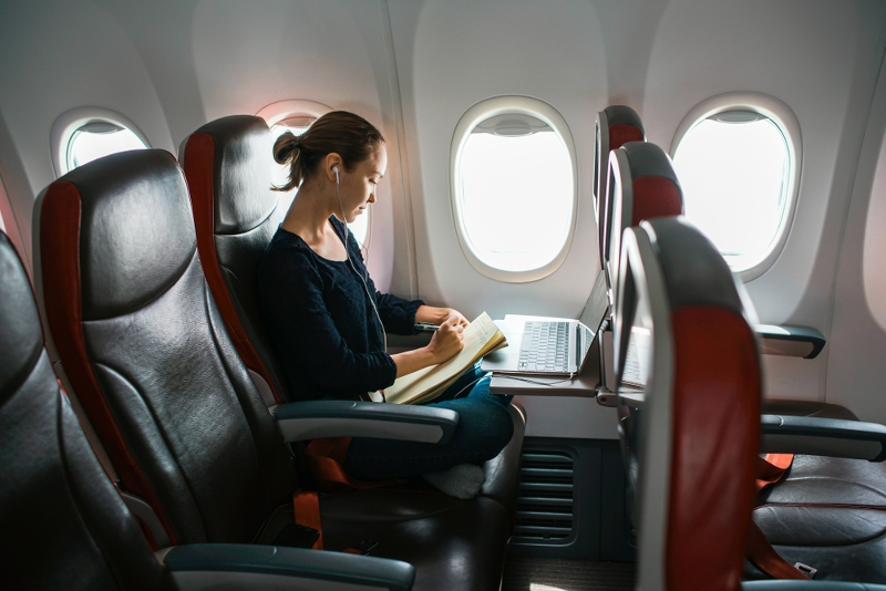 Žena se sluchátky sedí v letadle