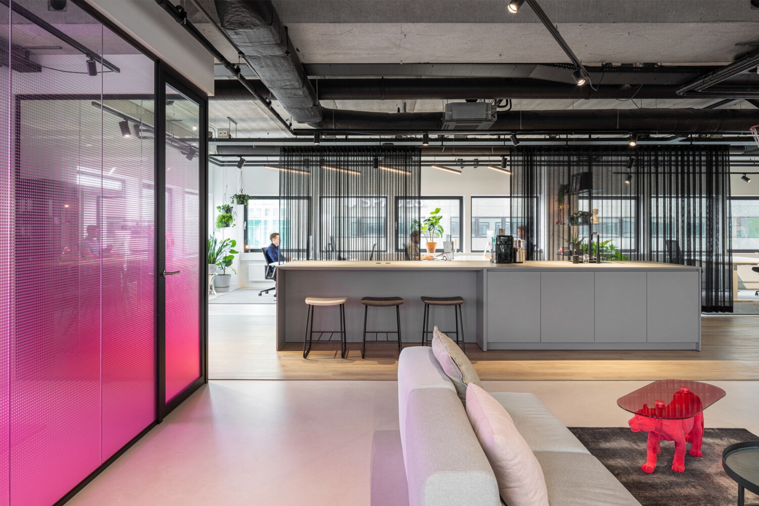 Interior of the Stuurmen office in Eindhoven with an open kitchen, seating area and pink glass wall
