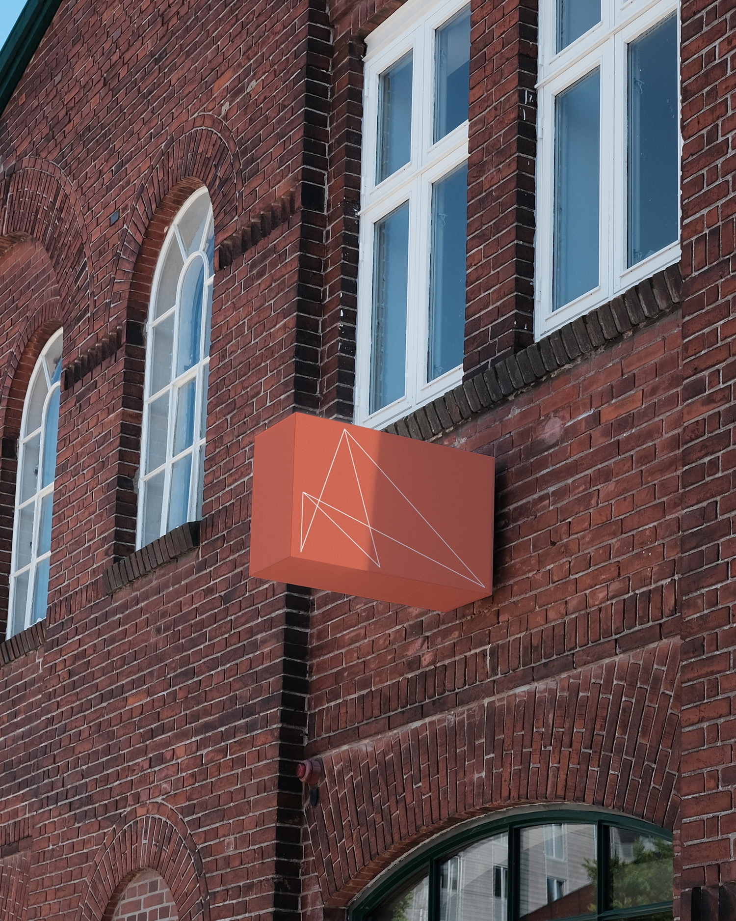 Terracottakleurig Mobuline uithangbord aan een monumentale bakstenen gevel.