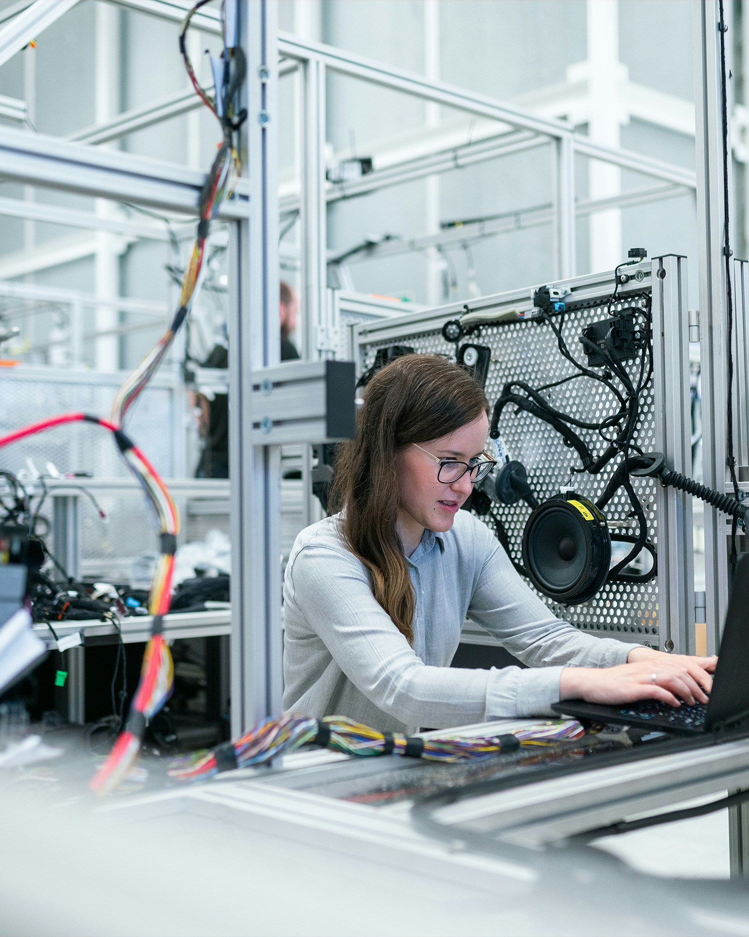 Vrouw werkt achter een computer bij een technische testopstelling