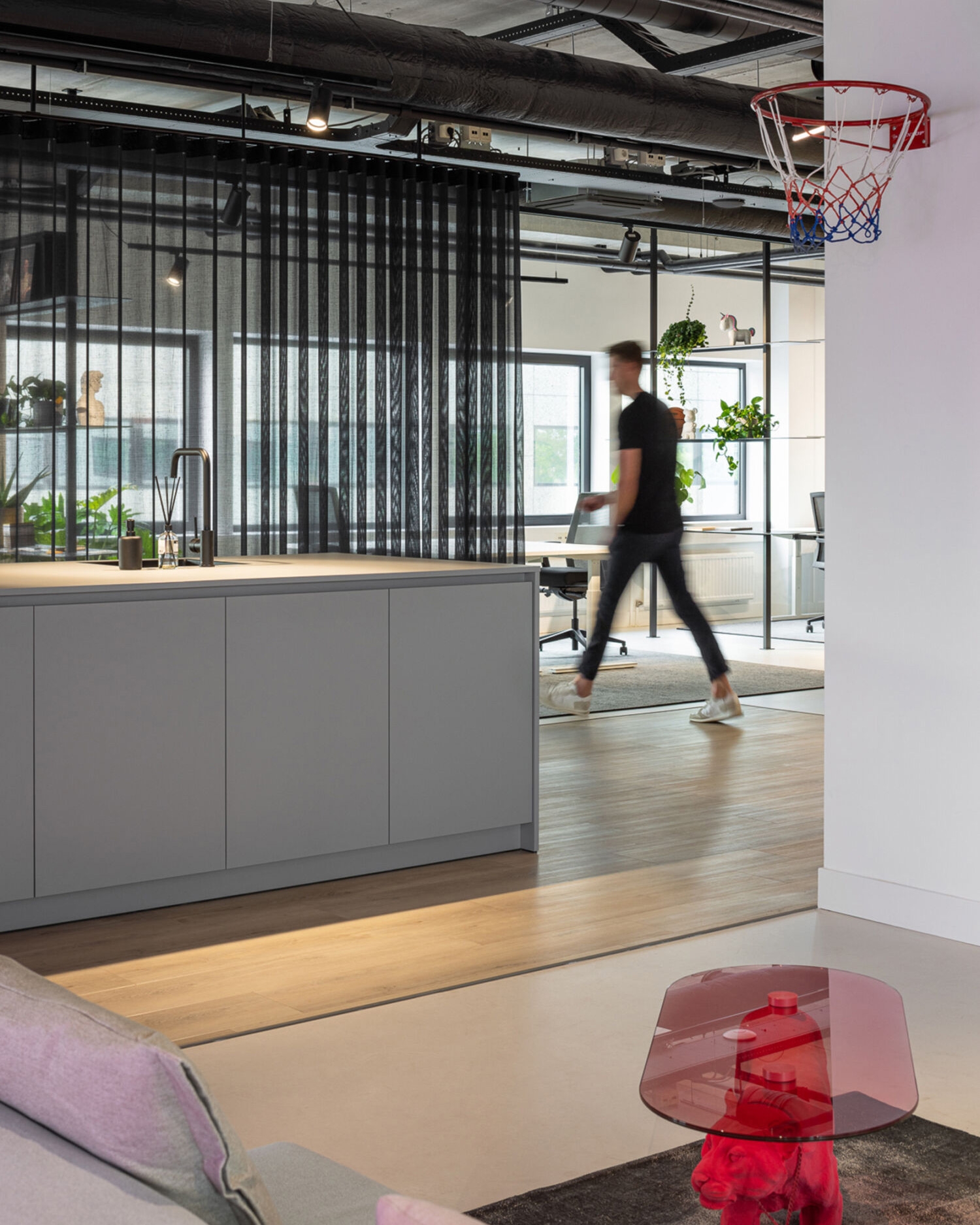 Lounge and kitchen in the Stuurmen office with an employee walking through the space