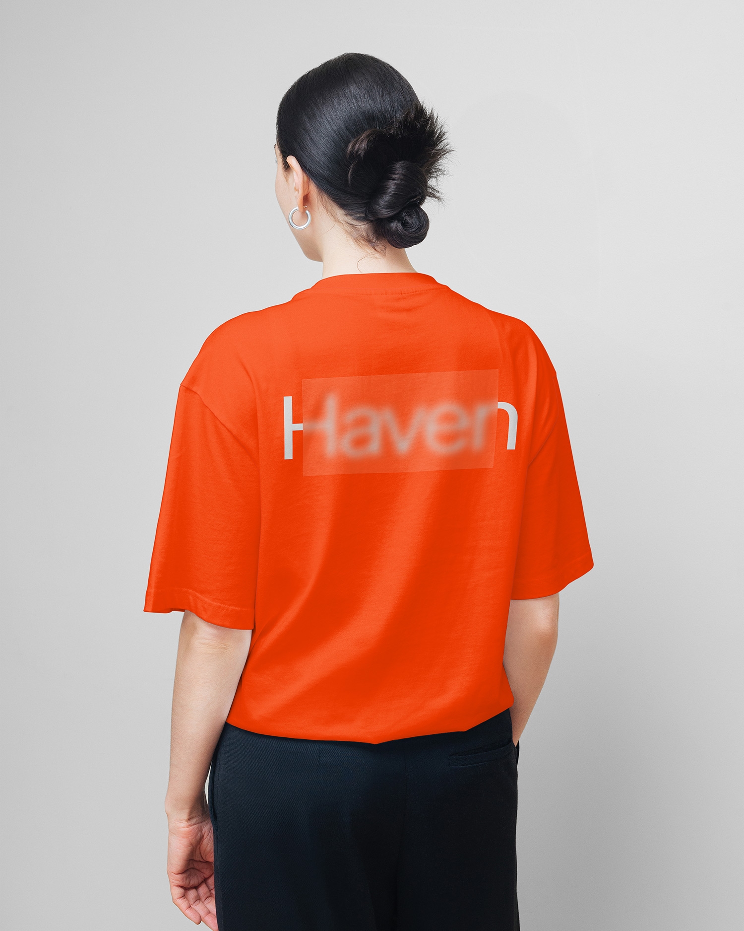 Persoon van achteren in een oranje T-shirt met het Haven-logo