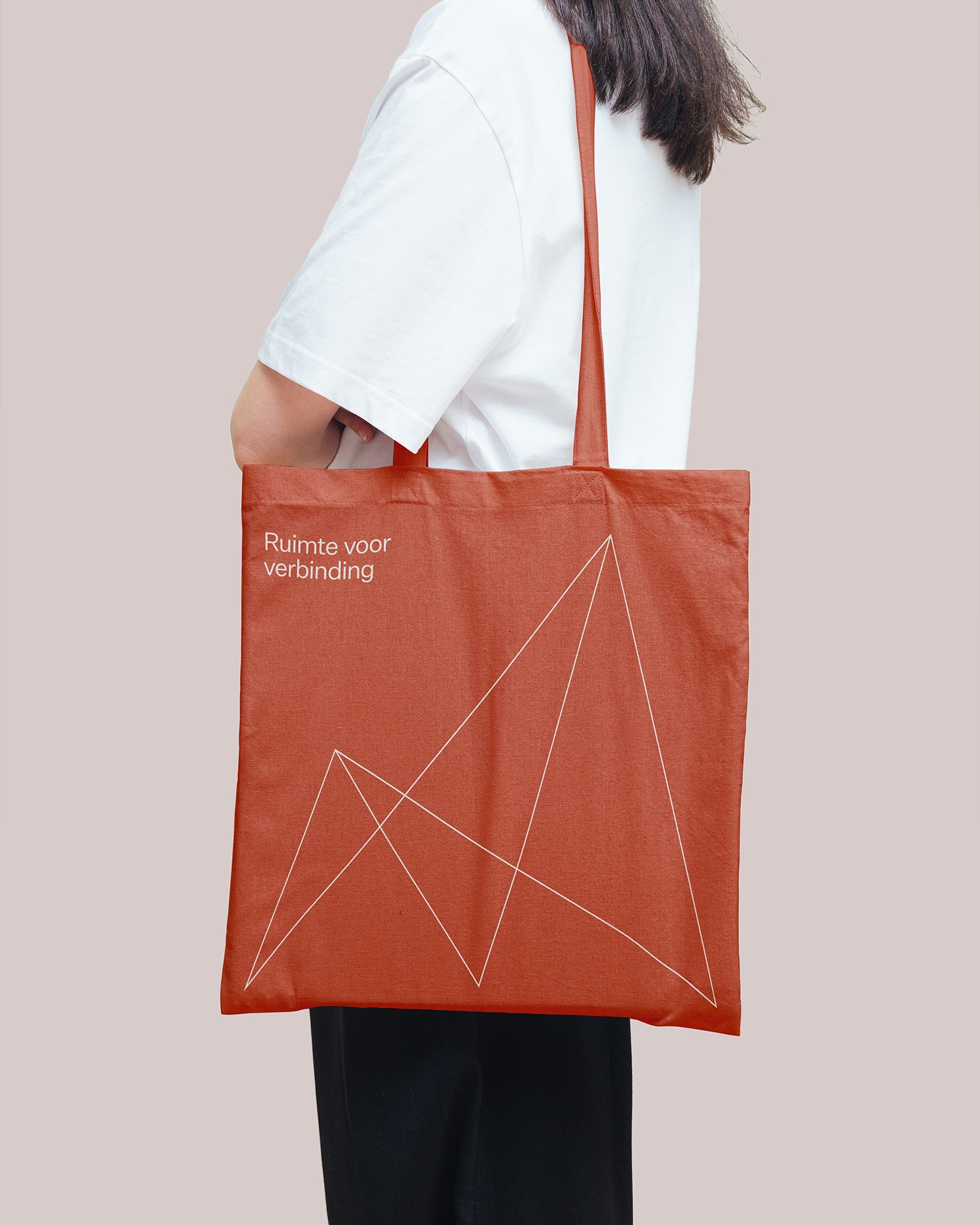 Persoon draagt een terracottakleurige Mobuline tas met de tekst Ruimte voor verbinding.
