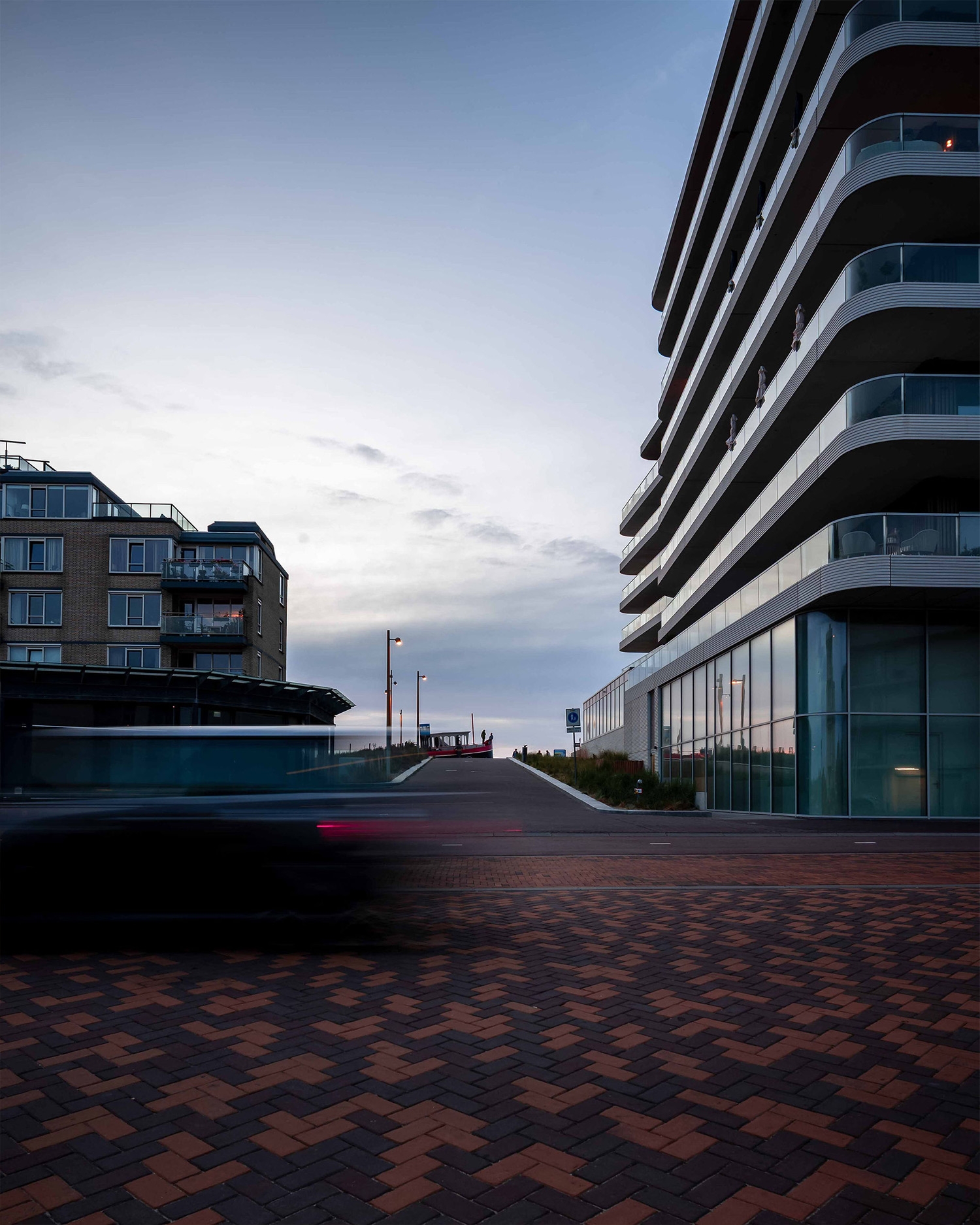Moderne architectuur aan het water met gebogen balkons, vastgelegd voor de nieuwe merkidentiteit van ZZDP.