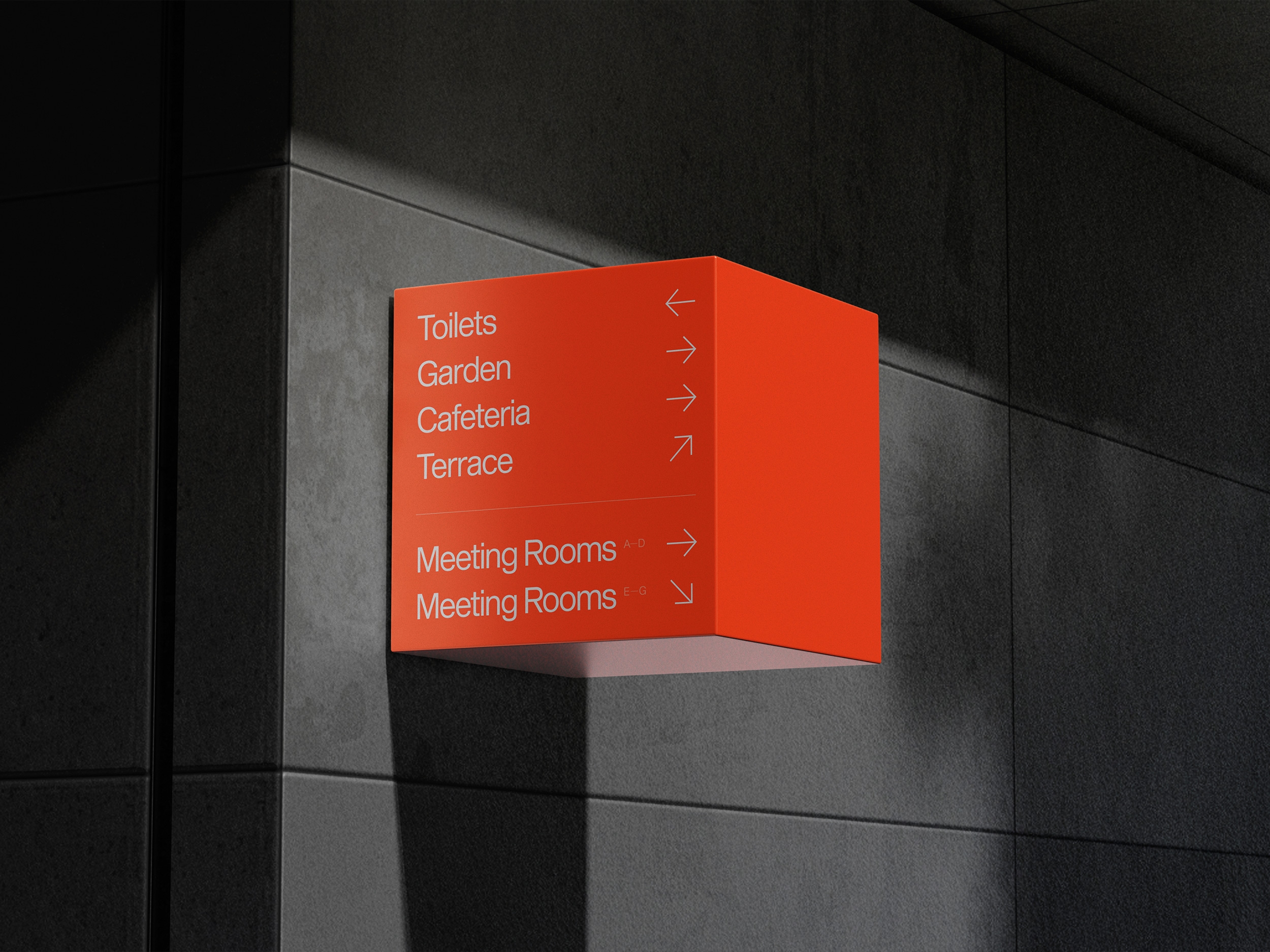 Oranje bewegwijzeringsbord met locaties en pijlen aan een donkere wand