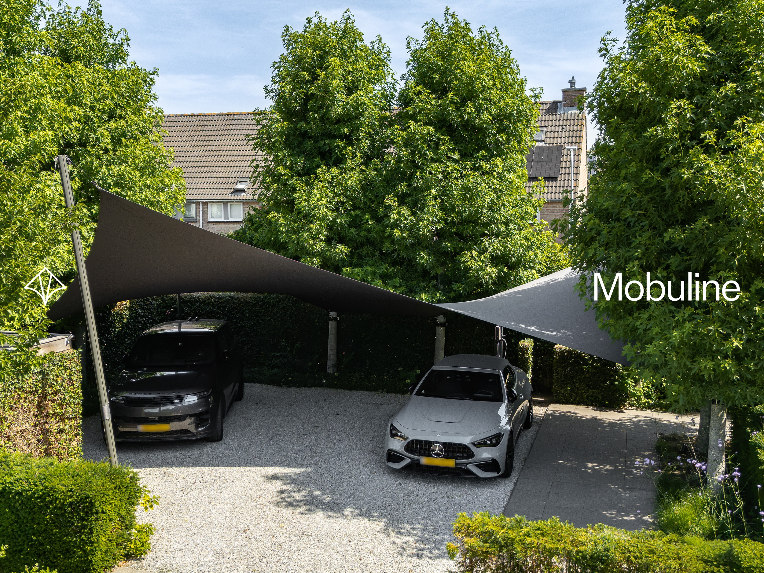 Twee Mobuline schaduwdoeken boven geparkeerde auto’s op een groene oprit.