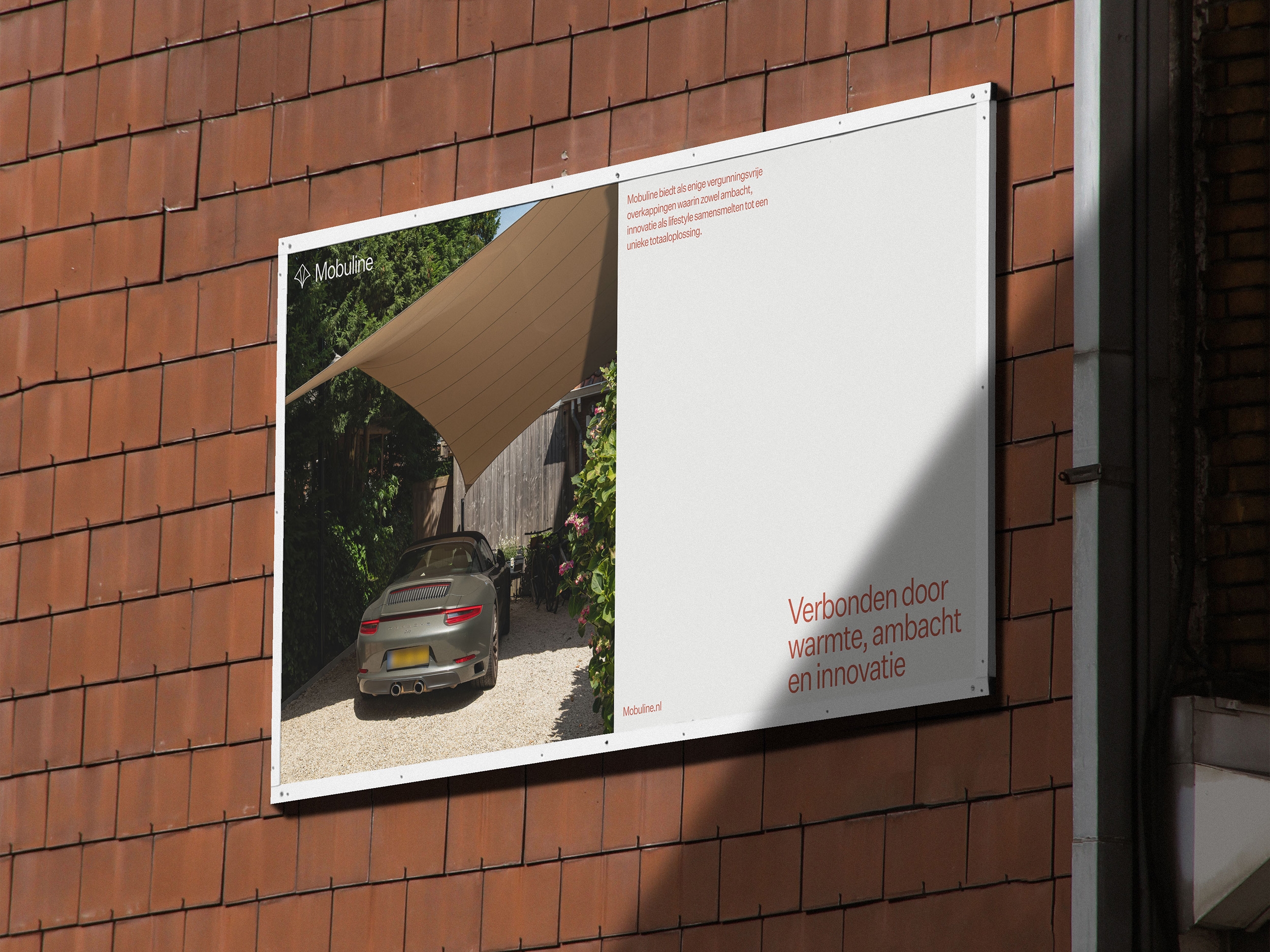 Mobuline campagneposter met een schaduwdoek op een bakstenen buitenmuur.