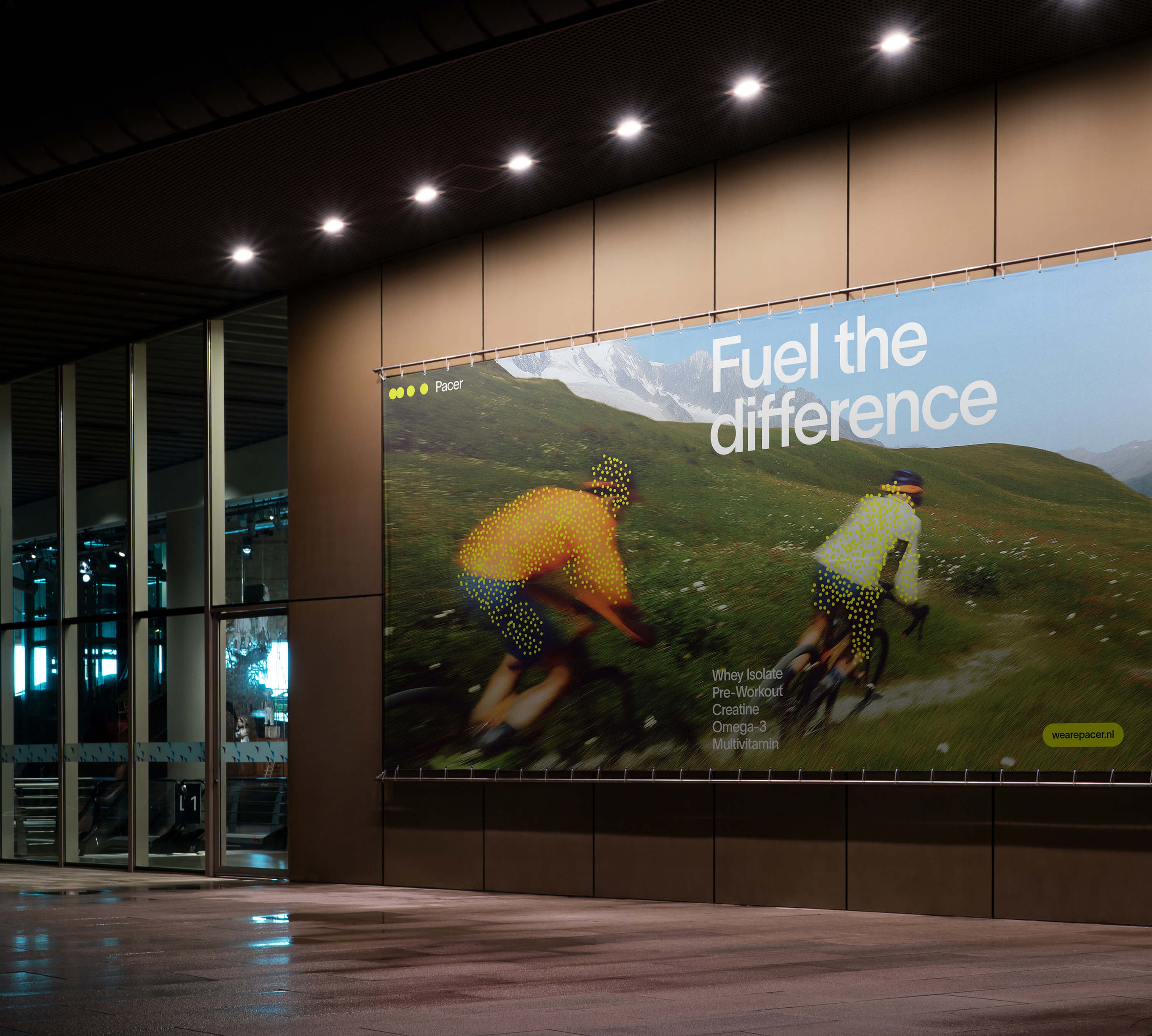 Billboard with cyclists on a green hill, featuring the text "Fuel the difference," promoting sports supplements.