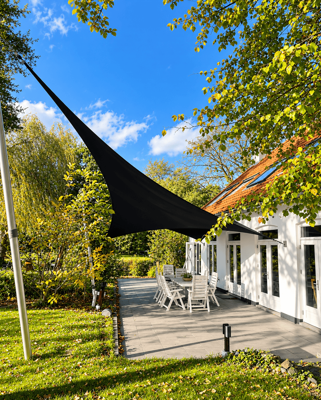 Maatwerk zonnedoek van Mobuline boven een ruim terras aan huis, omgeven door een groene tuin.