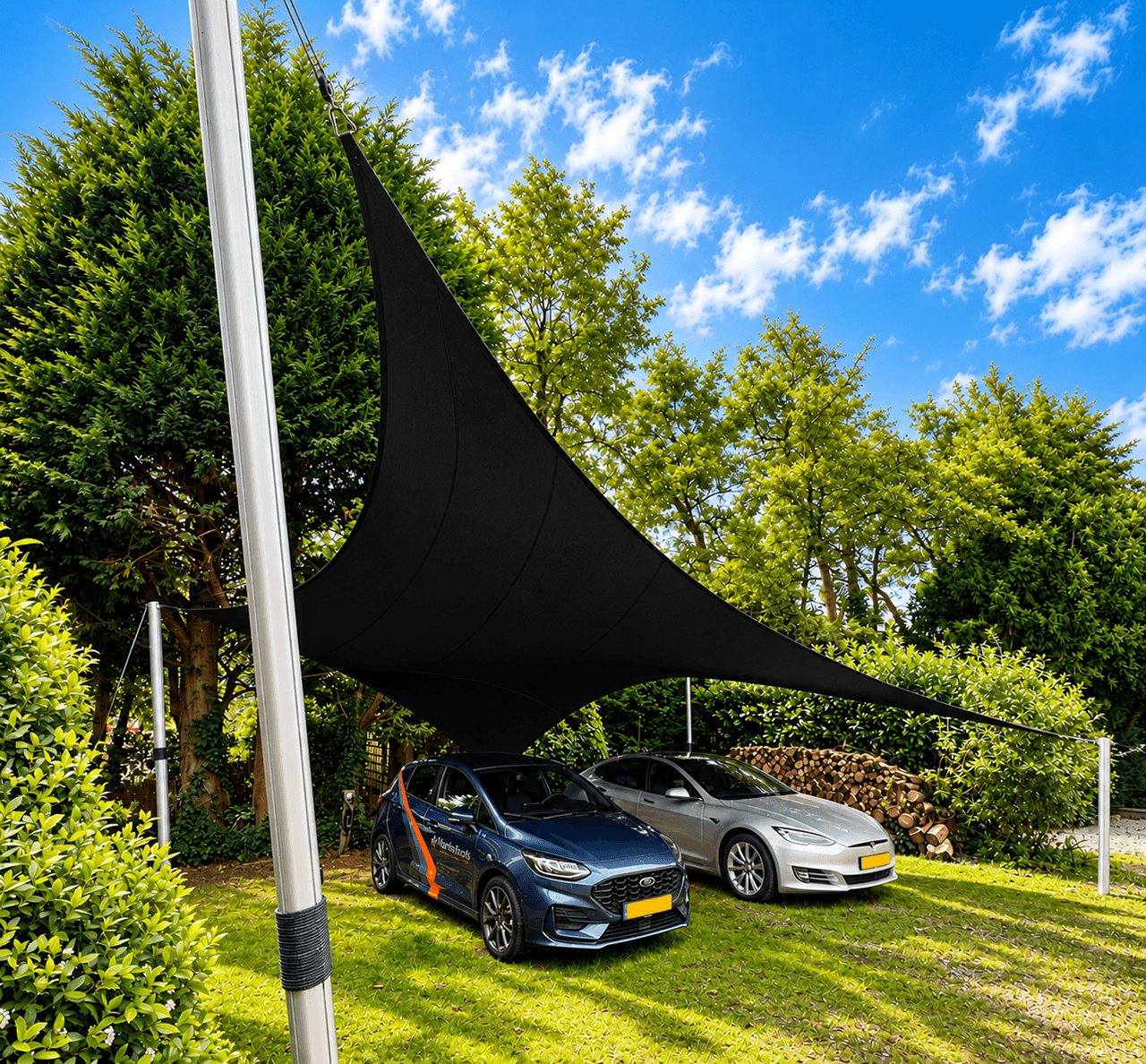 Zwarte design carport van gespannen textiel boven twee auto’s in een groene tuin.