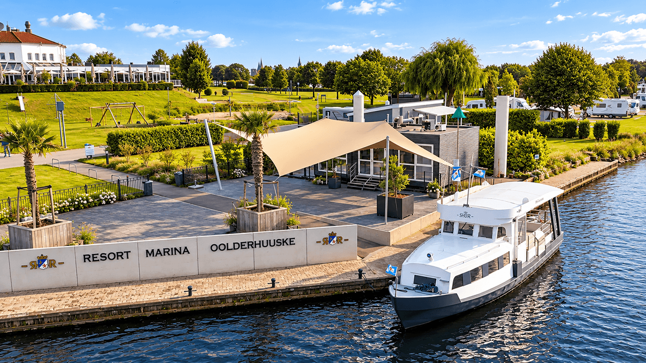 Maatwerk design schaduwdoek bij een jachthaven en resort, direct aan het water.