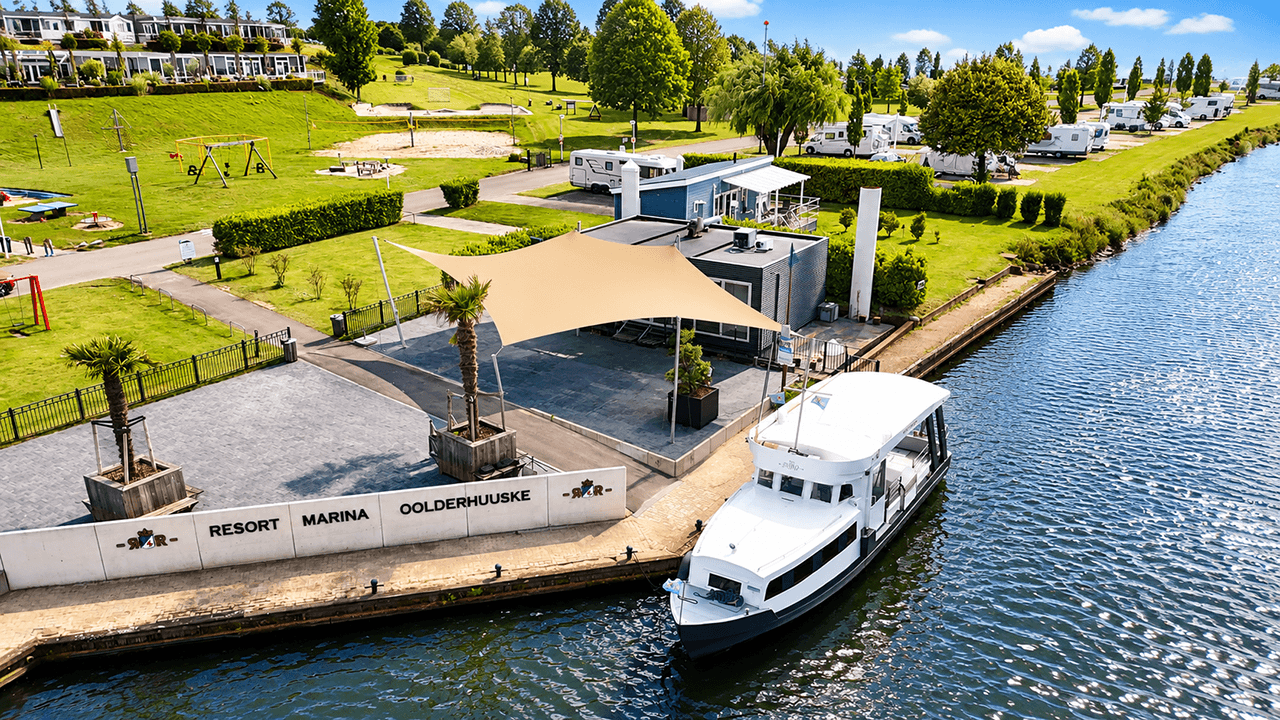 Maatwerk membraanoverkapping boven een terras aan de jachthaven van Resort Marina Oolderhuuske.