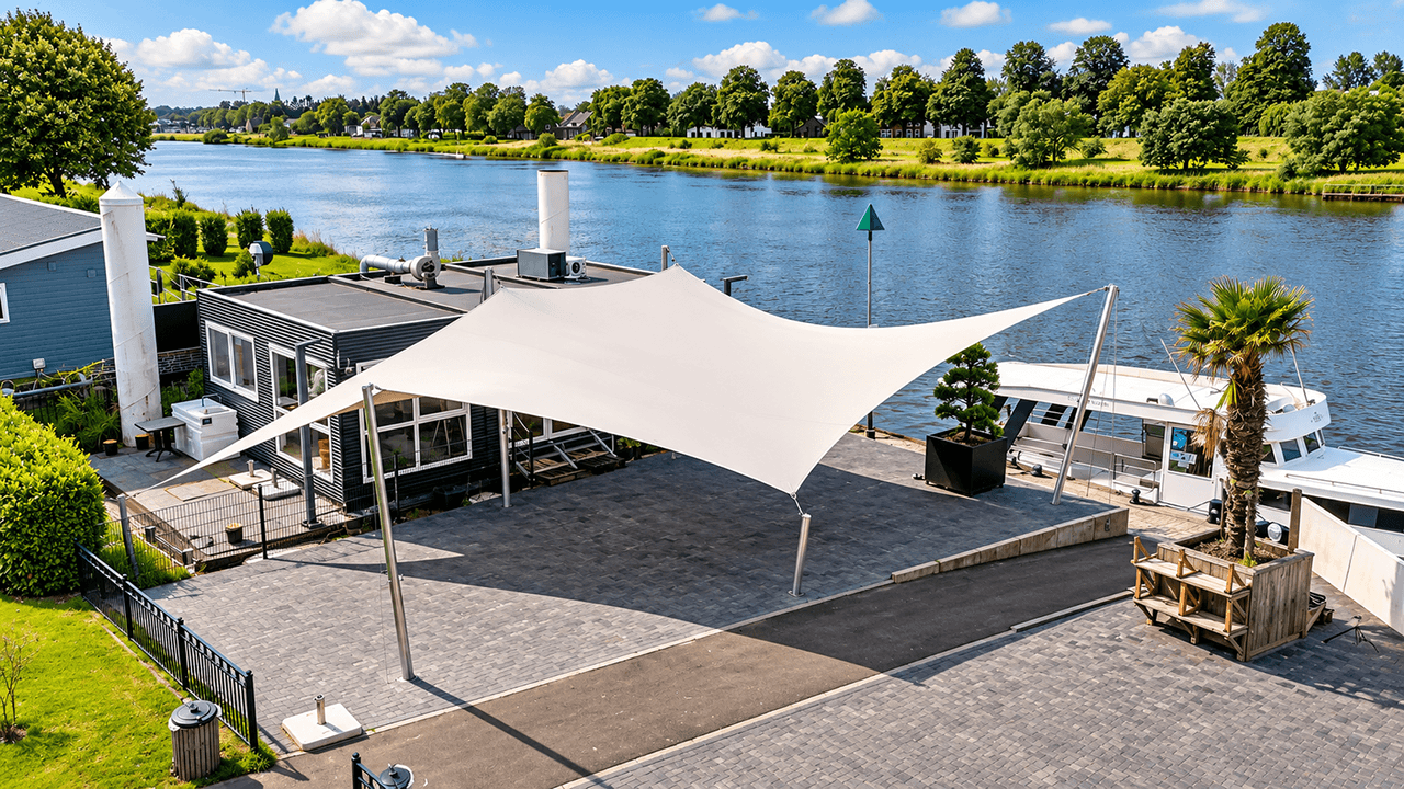 Grote maatwerk textiele overkapping van Mobuline boven een terras aan het water.