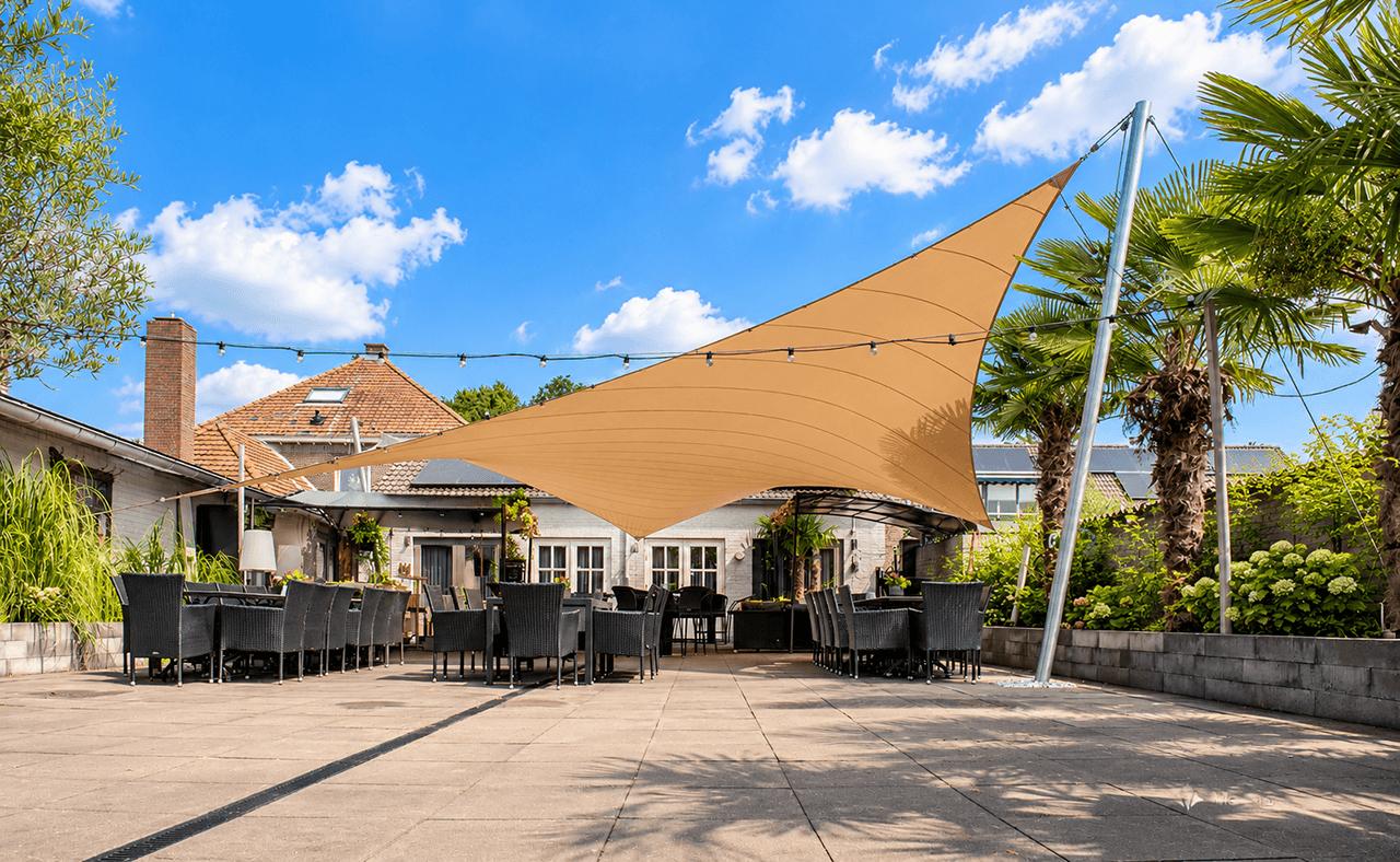 Groot maatwerk zonnedoek boven een ruim horecaterras met zitplaatsen en sfeerverlichting.