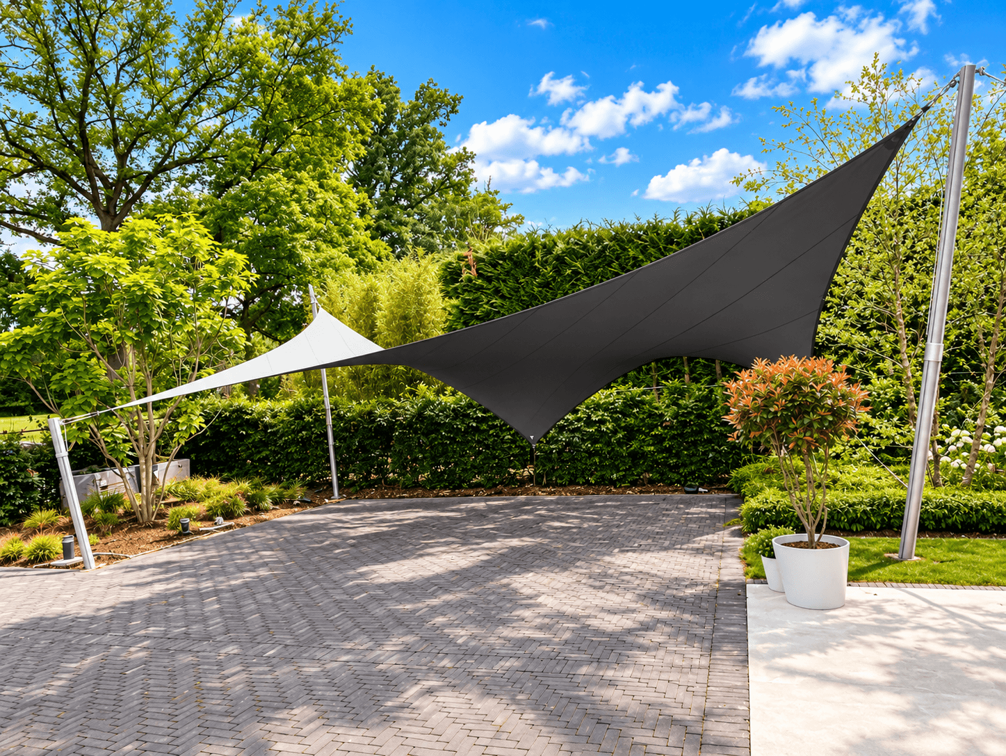 Zwart-witte design carport van gespannen textiel boven een ruime parkeerplaats in een groene tuin.
