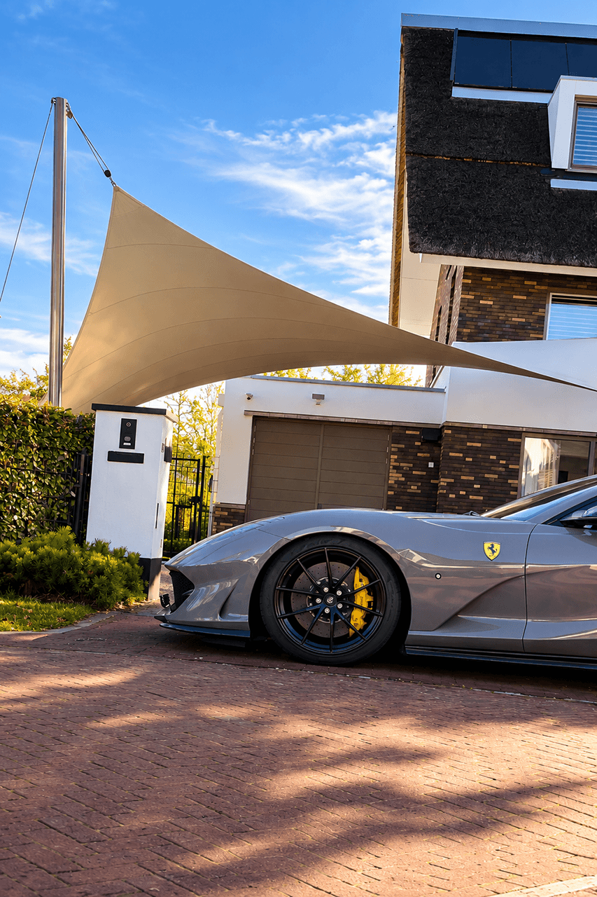 Architectonische textieloverkapping van Mobuline als maatwerk design carport voor een luxe sportwagen bij een moderne villa.