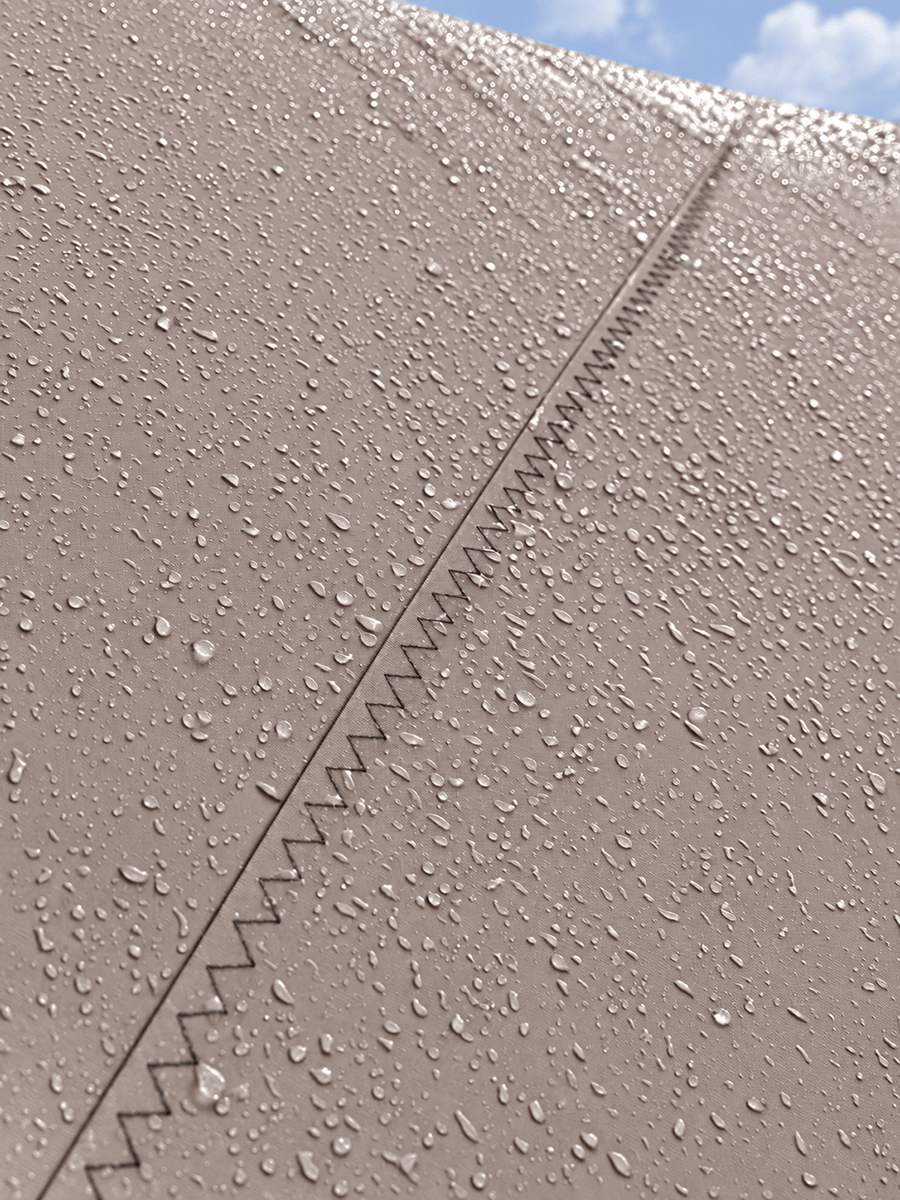 Detail van een waterdicht Mobuline zeildoek membraan met regendruppels en een verstevigde gestikte naad.