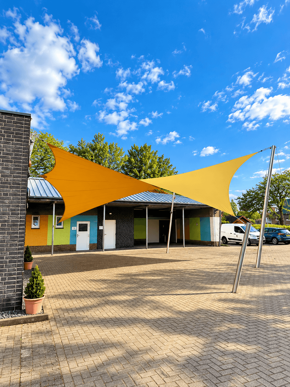 Maatwerk textiele overkapping boven een ruime buitenplaats bij een gebouw.