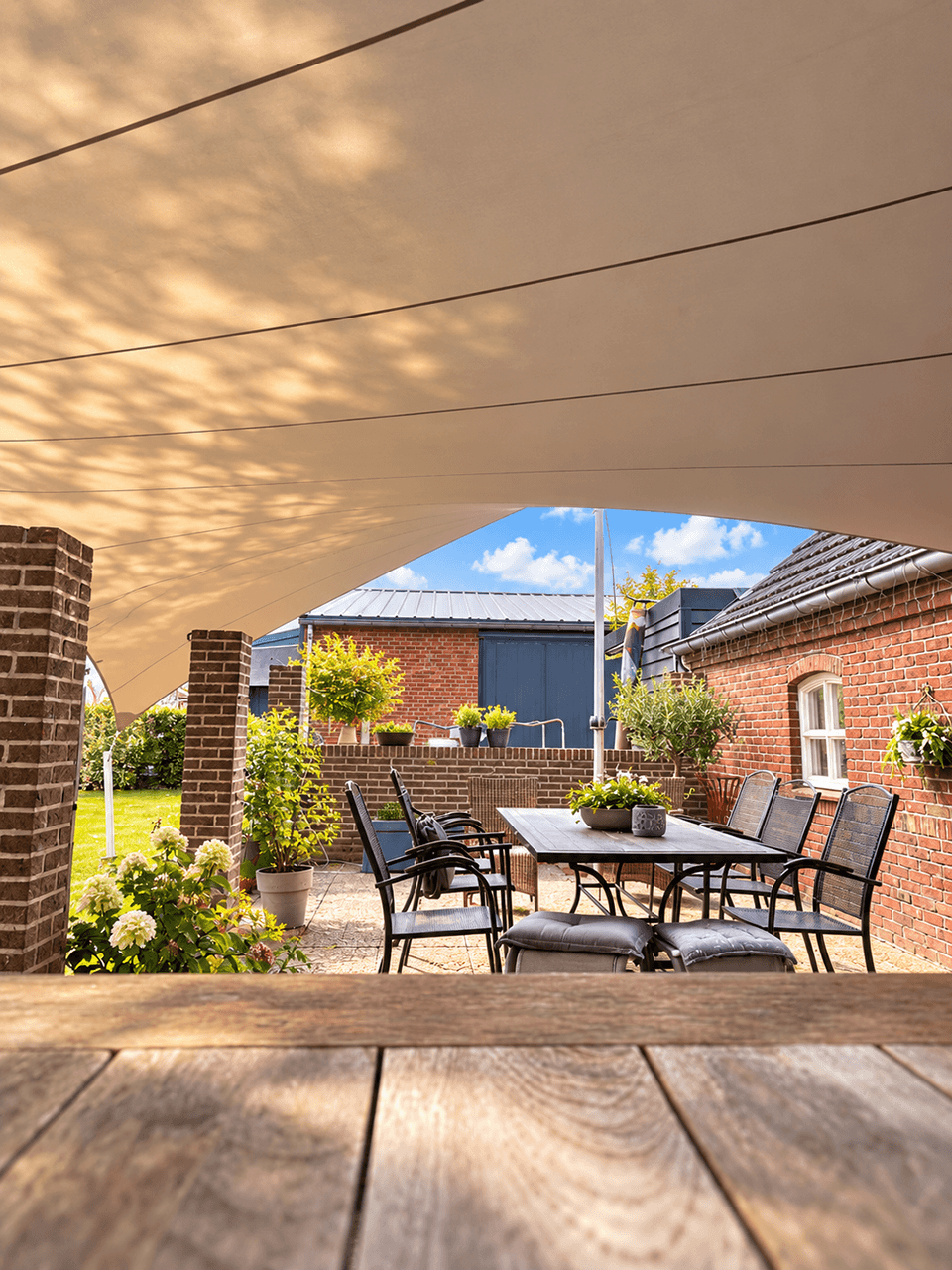 Maatwerk textiele overkapping boven een terras aan een landelijke woning.