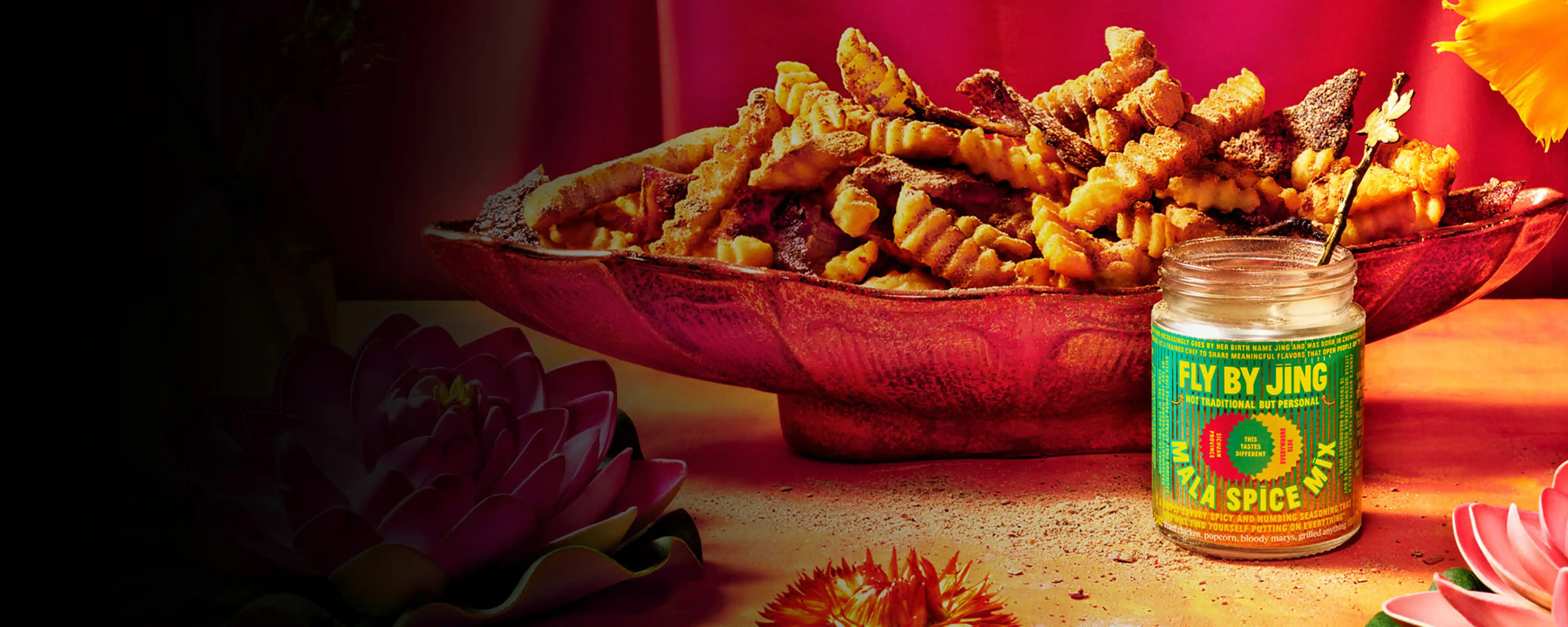 A jar of Mala Spice Mix with a bowl of fries in the back
