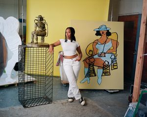 Tschabalala Self in her studio with a bronze sculpture and big yellow painting