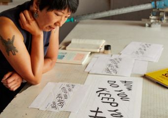 artist Christine Wong Yap in her studio looking at her work