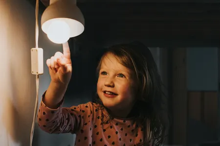 young girl pointing at lightbulb