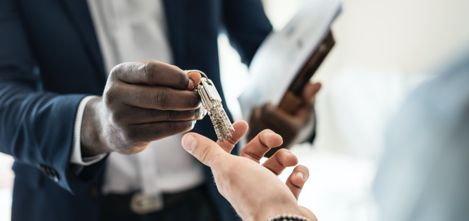 Un agent immobilier tend les clefs d'un appartment après un état des lieux d'entrée