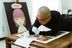 Hideaki Kawashima leaning over a table working on finishing a print
