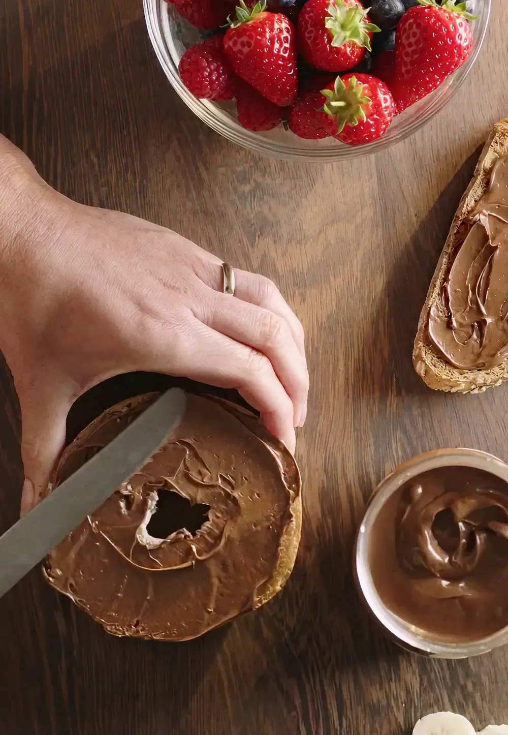Hands slicing a chocolate roll beside a bowl of strawberries, from the Sound of Nutella campaign