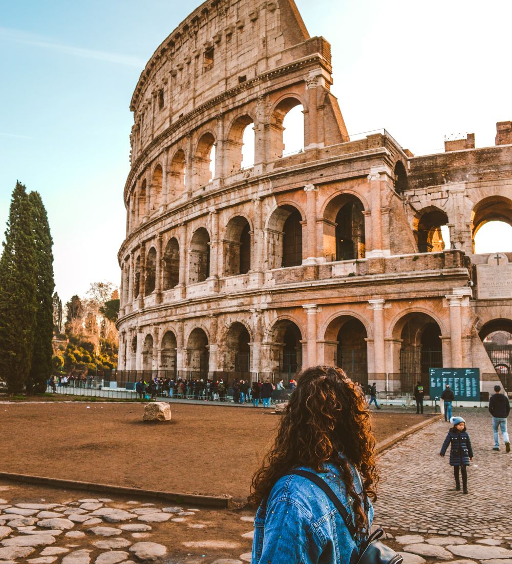 woman standing in front of the colosseum in rome italy