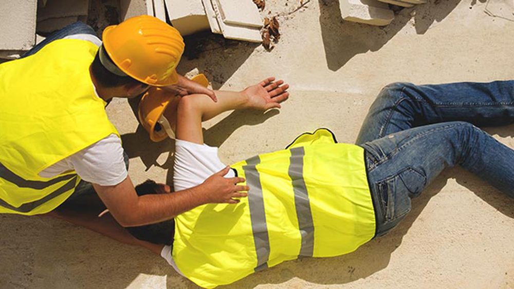 A person giving first aid to a builder