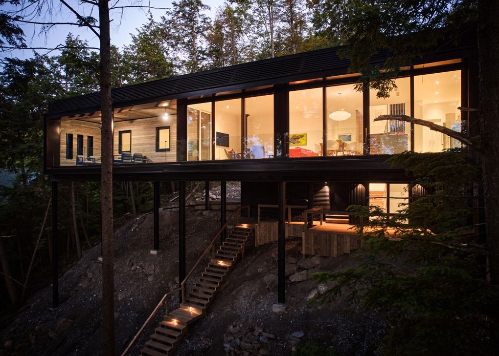 A cottage on stilts rises above the tree canopy near Ottawa