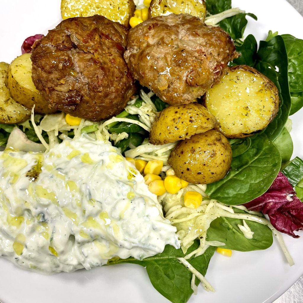 Klimatsmarta grekiska biffar serveras med tzatziki och örtrostad potatis