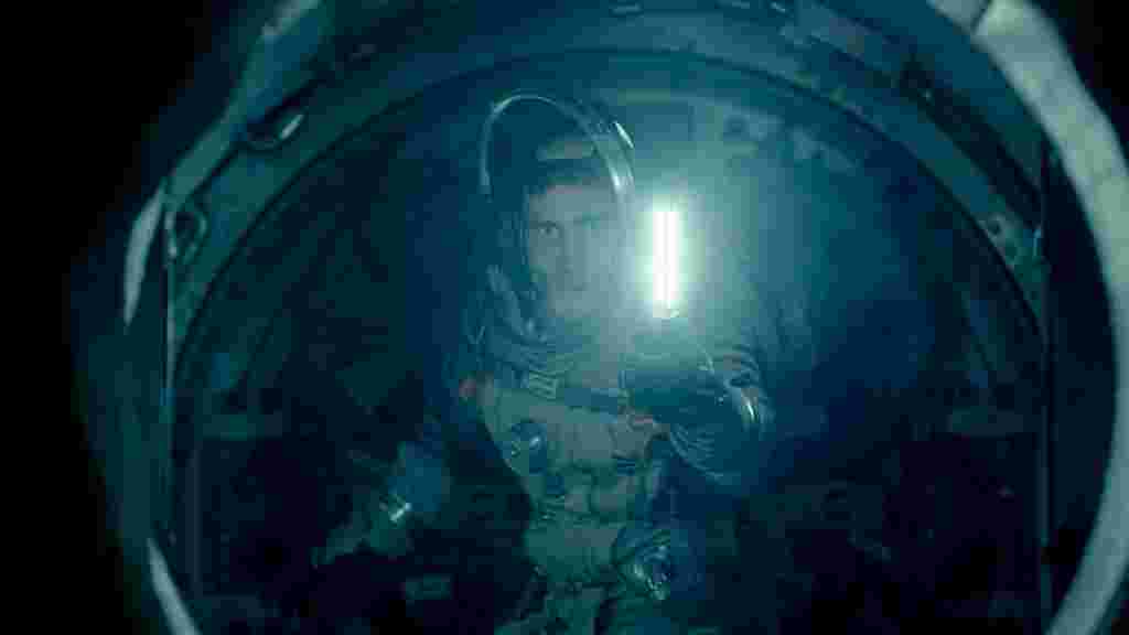 A spaceman holding a light looking through a spherical window