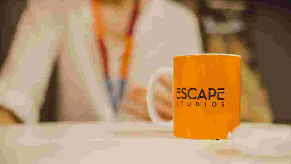 Orange Escape Studios mug on a table